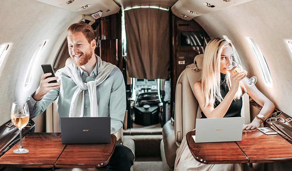 Mann und Frau mit Acer Swift Notebooks sitzen im Privatjet